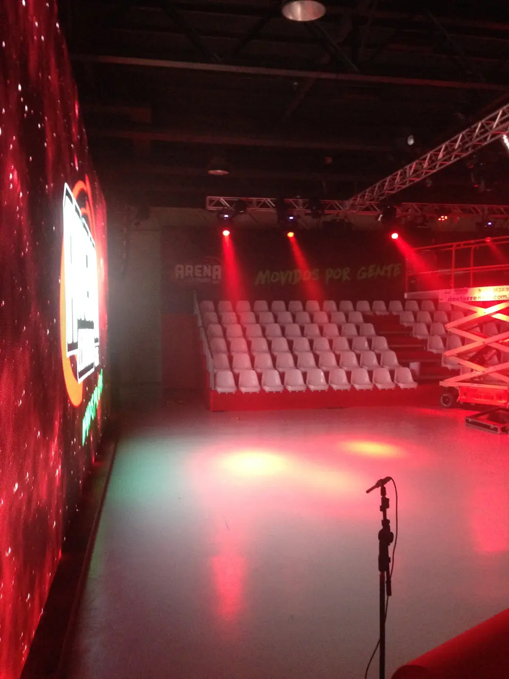 Teatro com iluminação vermelha e fileiras de cadeiras