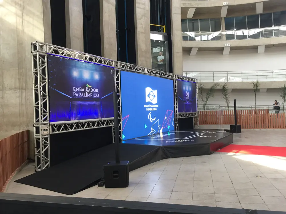 Evento corporativo ao ar livre com telões em estrutura de truss