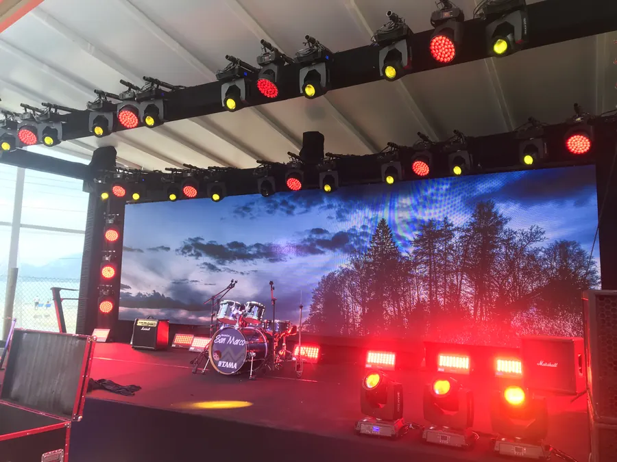 Palco com iluminação em vermelho e amarelo e telão de LED ao fundo